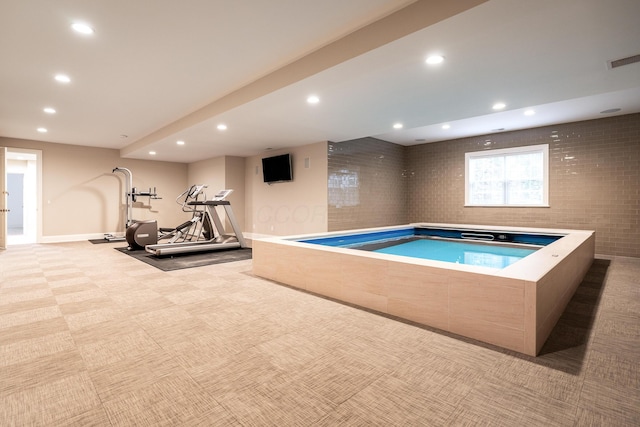 view of swimming pool featuring an indoor hot tub