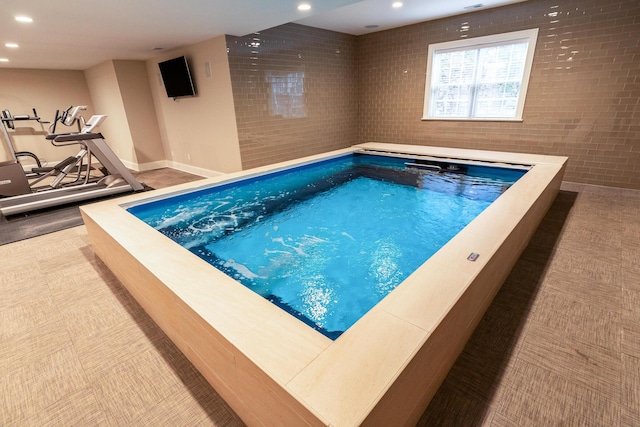 view of pool with an indoor hot tub