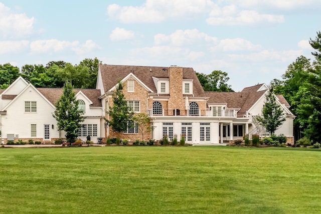 back of property with french doors and a yard