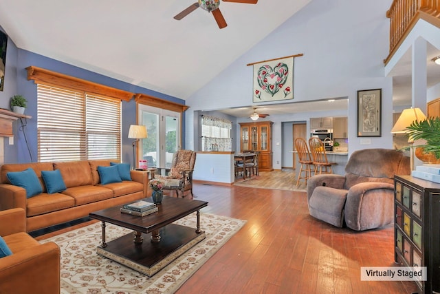 living room with ceiling fan, light hardwood / wood-style flooring, and high vaulted ceiling