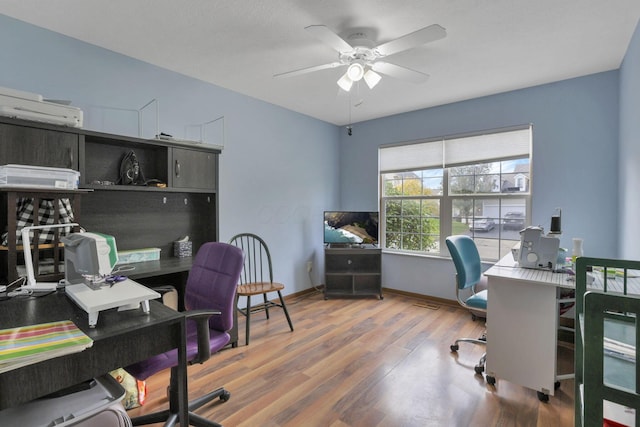 office space with hardwood / wood-style floors, an AC wall unit, and ceiling fan