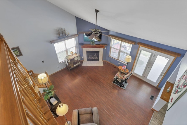 unfurnished living room with hardwood / wood-style floors, ceiling fan, a fireplace, and high vaulted ceiling