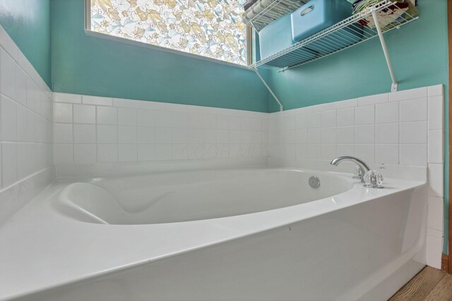 bathroom with a bath and hardwood / wood-style floors