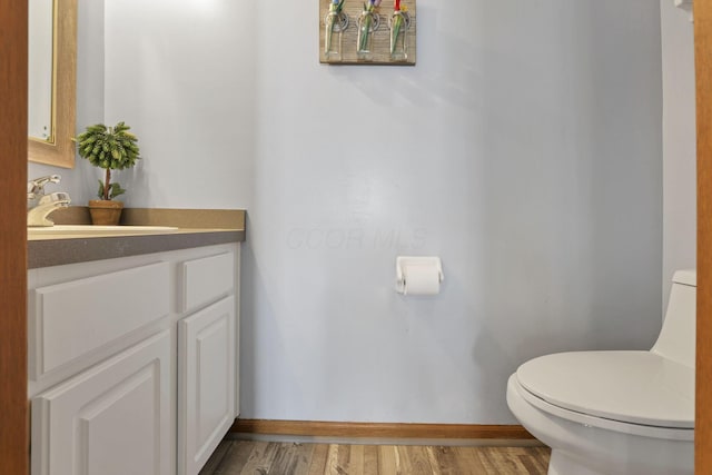 bathroom with vanity, toilet, and wood-type flooring