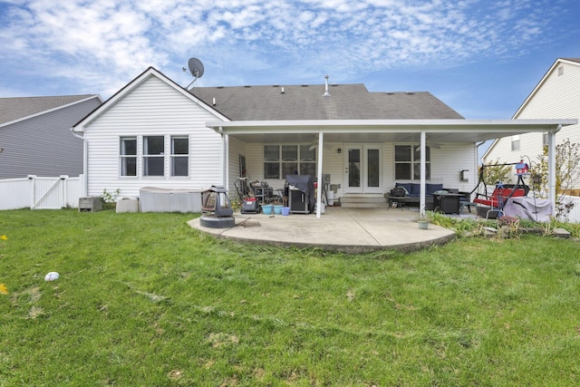 back of property with a lawn and a patio