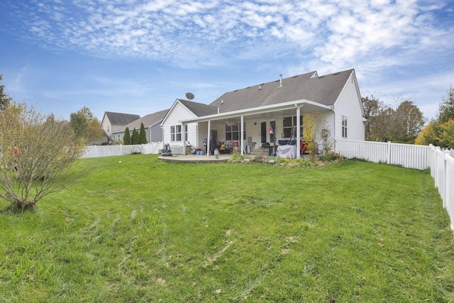 rear view of house featuring a yard and a patio