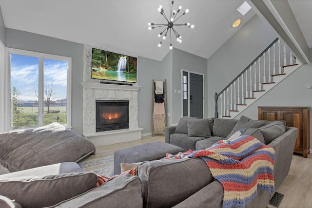 living room with an inviting chandelier, light hardwood / wood-style flooring, and plenty of natural light