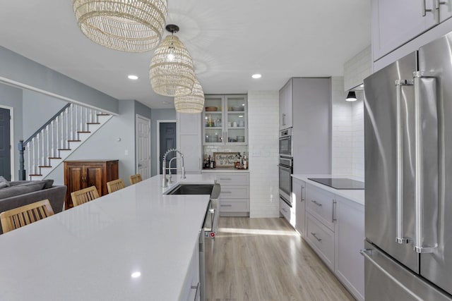 kitchen featuring tasteful backsplash, a breakfast bar area, high end refrigerator, and decorative light fixtures