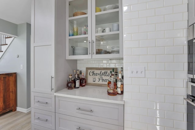 bar featuring white cabinets and light wood-type flooring