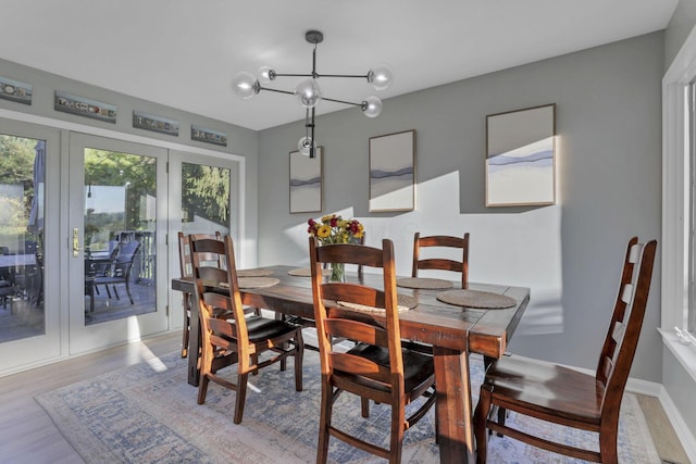 dining area with hardwood / wood-style floors and a chandelier