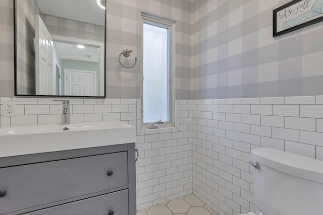 bathroom with tile walls, vanity, and toilet