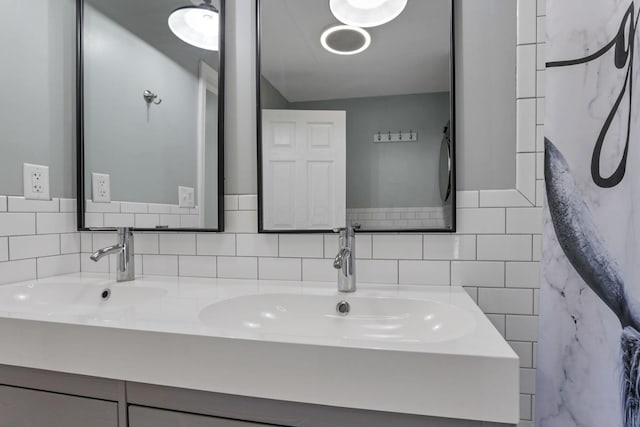 bathroom featuring vanity and tile walls