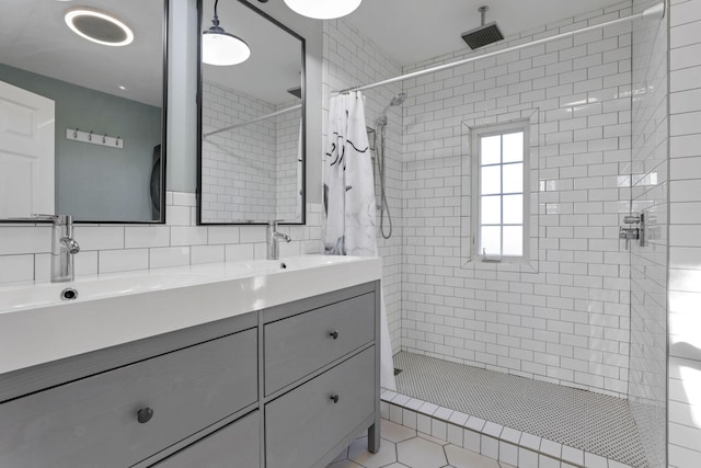 bathroom with tile patterned flooring, vanity, curtained shower, and tile walls