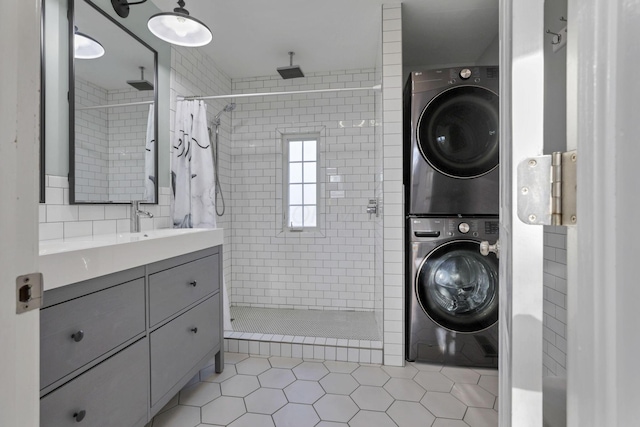 bathroom with tile patterned floors, stacked washer and clothes dryer, curtained shower, and vanity