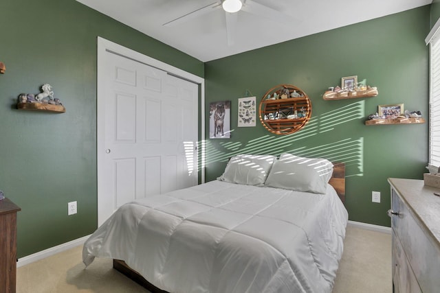 carpeted bedroom featuring ceiling fan and a closet