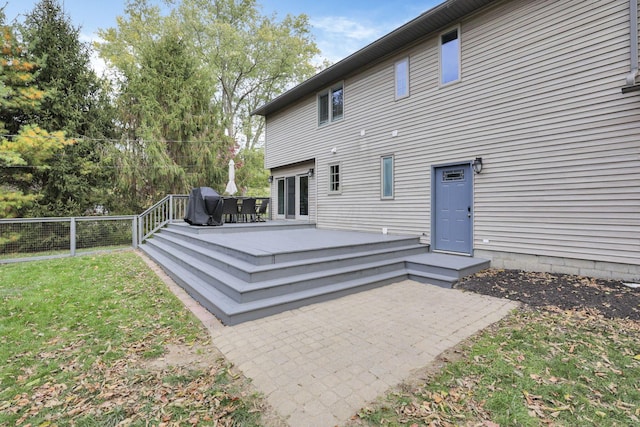 back of property featuring a yard, a deck, and a patio area