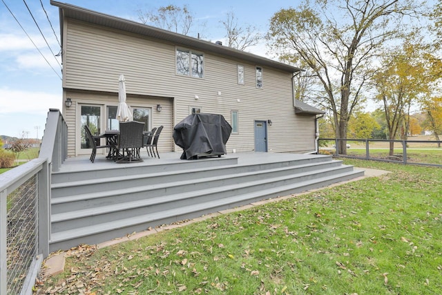 back of house with a wooden deck and a lawn