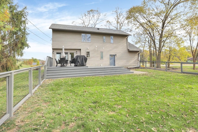 rear view of house with a wooden deck and a lawn