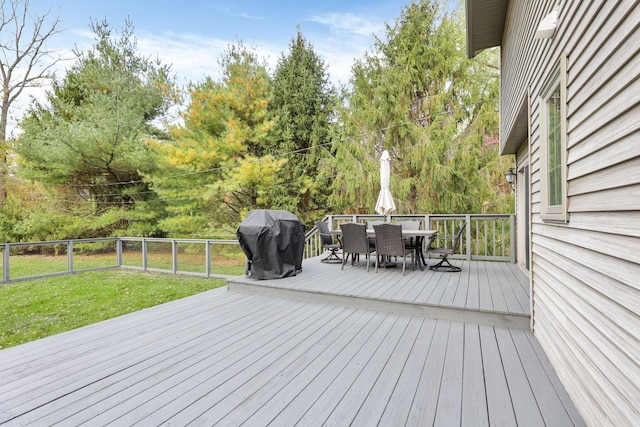 wooden deck featuring grilling area and a lawn