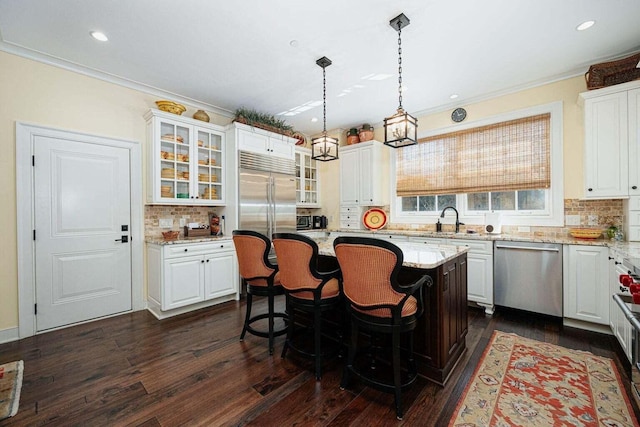 kitchen with a center island, tasteful backsplash, decorative light fixtures, dark hardwood / wood-style flooring, and stainless steel appliances