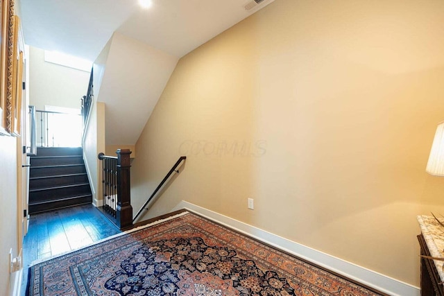 staircase with wood-type flooring and lofted ceiling