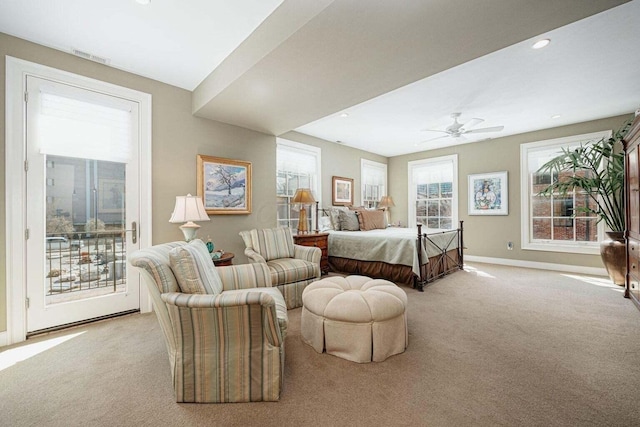 bedroom featuring access to exterior, light colored carpet, multiple windows, and ceiling fan