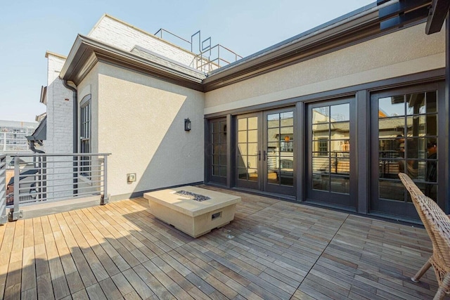 wooden deck featuring french doors and an outdoor fire pit