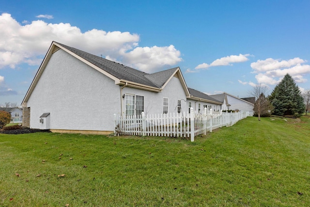 view of side of home with a yard