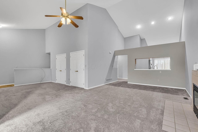 unfurnished living room featuring carpet flooring, high vaulted ceiling, and ceiling fan