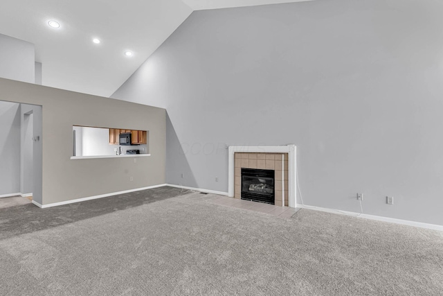 unfurnished living room with carpet, a fireplace, and high vaulted ceiling