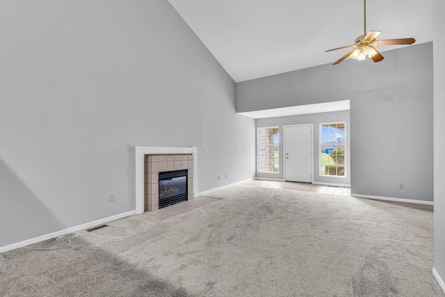 unfurnished living room with light carpet, high vaulted ceiling, ceiling fan, and a tiled fireplace