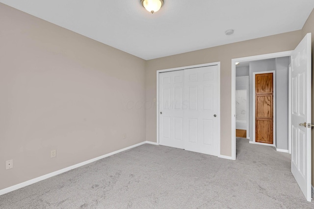 unfurnished bedroom featuring light carpet and a closet