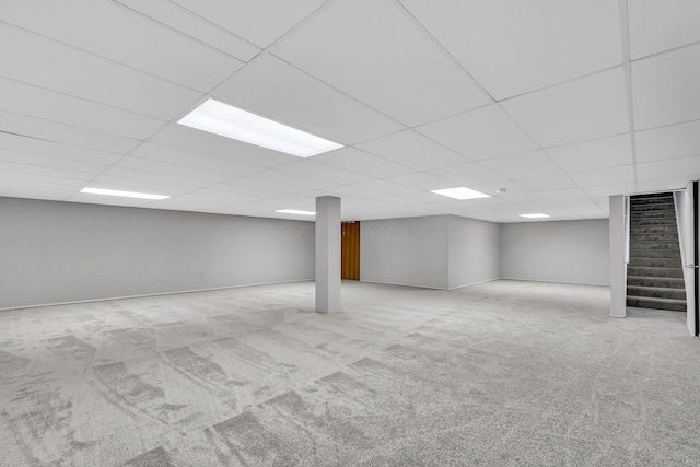 basement featuring light carpet and a drop ceiling