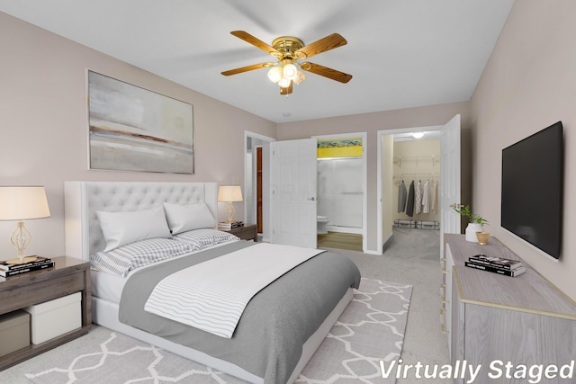 bedroom featuring a walk in closet, ceiling fan, connected bathroom, light colored carpet, and a closet