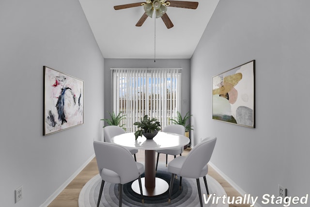 dining area featuring ceiling fan, light wood-type flooring, and vaulted ceiling