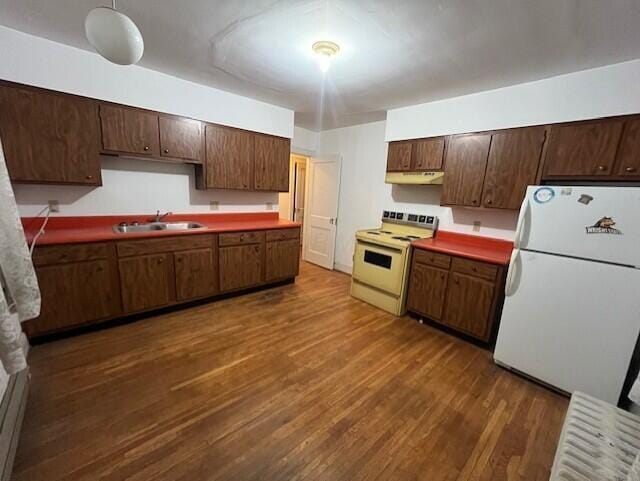 kitchen with dark hardwood / wood-style flooring, range with electric cooktop, dark brown cabinetry, sink, and white refrigerator