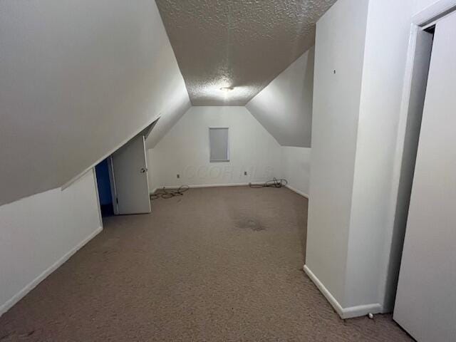 bonus room featuring a textured ceiling, carpet flooring, and lofted ceiling