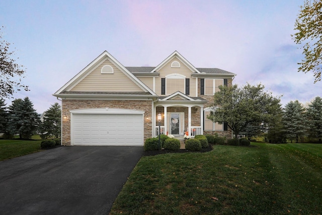 view of front of home with a garage and a yard