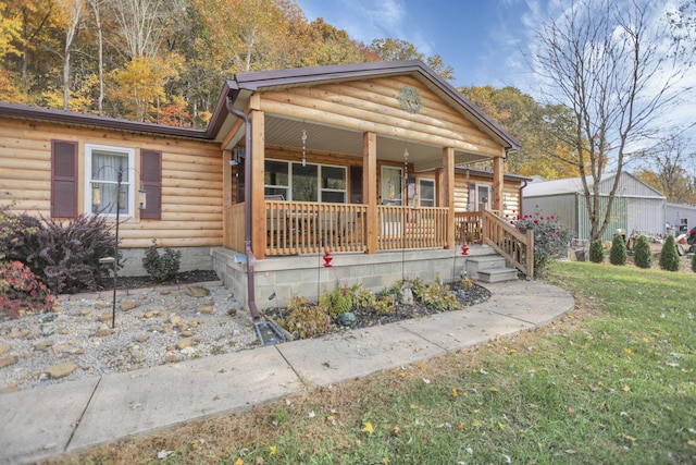 log cabin with a porch and a front lawn