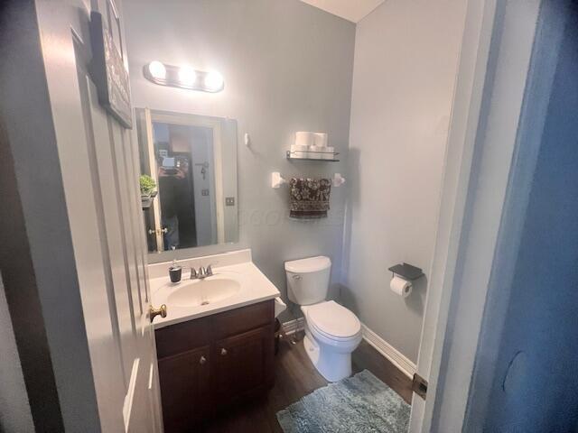 bathroom featuring hardwood / wood-style flooring, vanity, and toilet