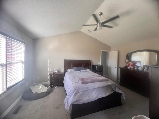 carpeted bedroom with a textured ceiling, vaulted ceiling, and ceiling fan