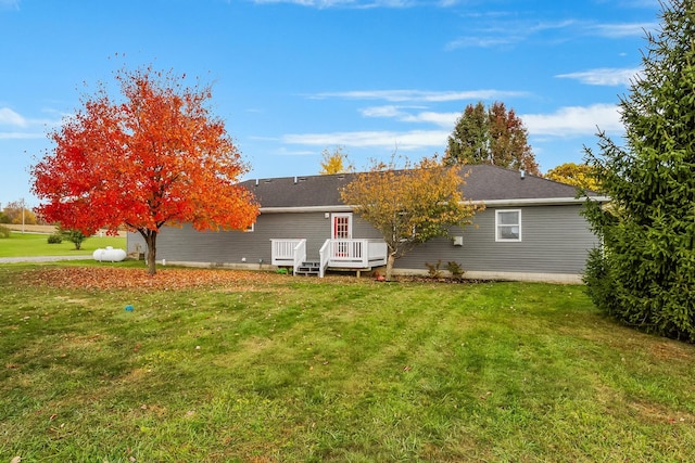 rear view of property featuring a lawn and a wooden deck