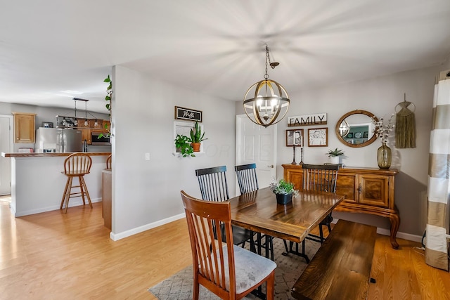 dining space featuring light hardwood / wood-style floors and a notable chandelier