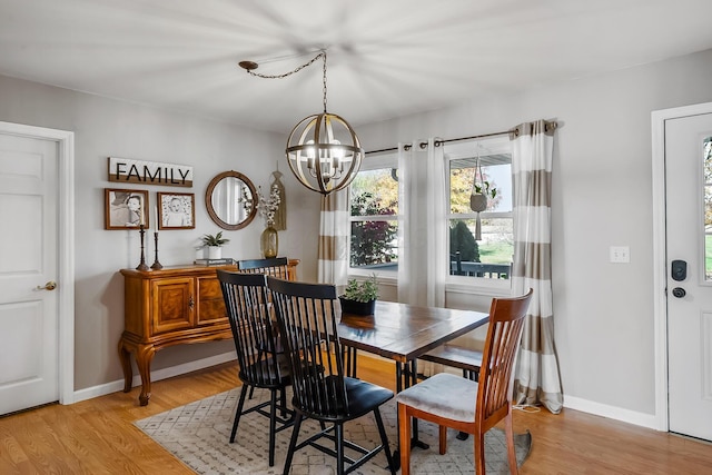 dining space with a chandelier and light hardwood / wood-style flooring