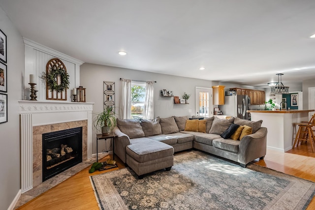 living room with light hardwood / wood-style floors and a tile fireplace