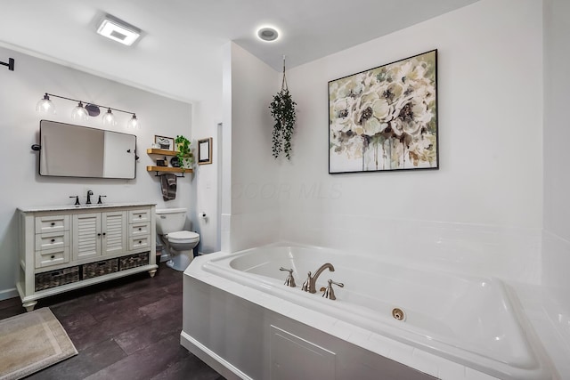 bathroom with hardwood / wood-style floors, vanity, toilet, and tiled bath