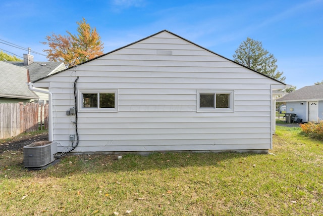 view of property exterior with a yard and central AC