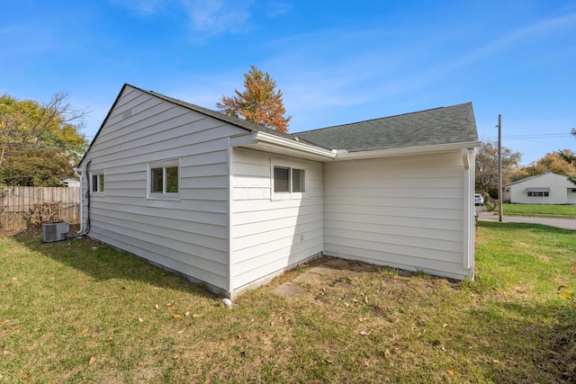 view of property exterior with central air condition unit and a lawn