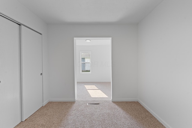 unfurnished bedroom with carpet and a closet