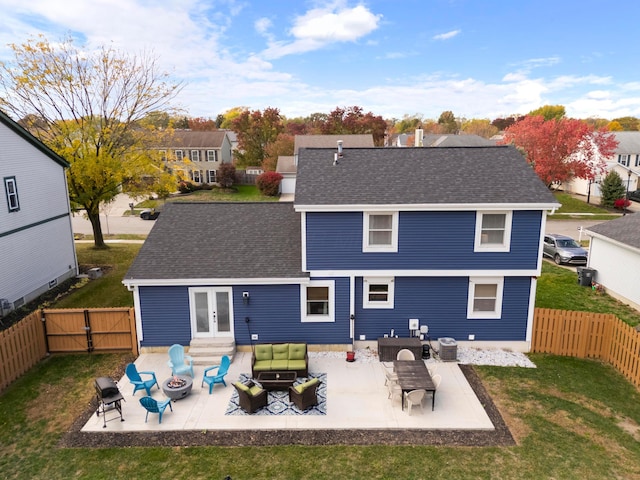 back of property with a yard, french doors, central AC, an outdoor living space with a fire pit, and a patio